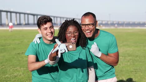 Cheerful-volunteers-taking-selfie-with-smartphone